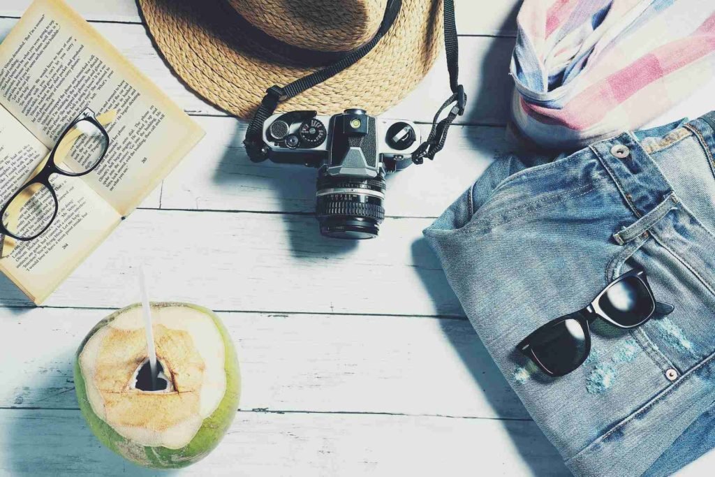 some travel essentials laid out on a white wooden table